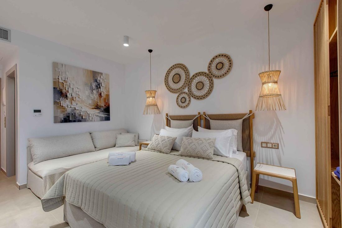 A Linari suite: double bed, daybed, rattan lamps and woven wall plates