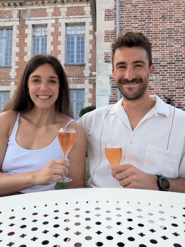 Two glasses of rosé in front of a brick château